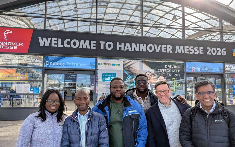 Mitglieder einer internationalen Delegation posieren vor dem Haupteingang der Hannover Messe 2026.